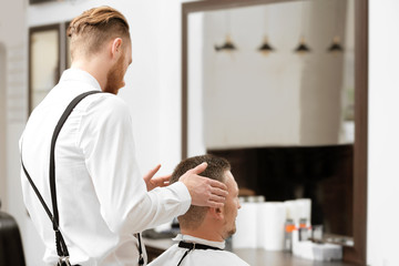 Naklejka na ściany i meble Barber making modern male hairstyle