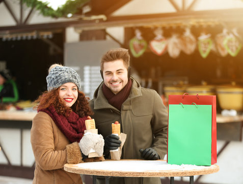 Cute couple having lunch break on winter market