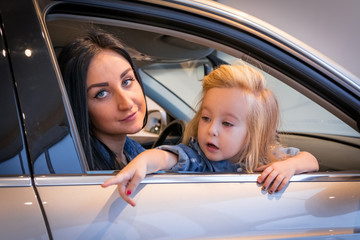 Girl and mom in exhibition hall for car