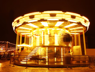 Bright carousel in city at night