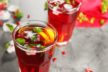 Two glasses of cold fruit cocktail on gray background