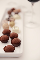 Delicious chocolates on white table closeup