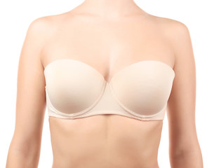 Young woman in beige bra on white background