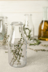 Bottle with thyme on table