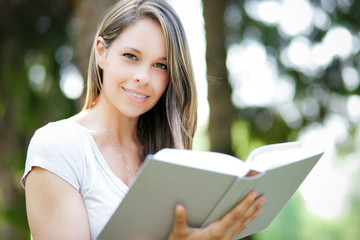 Fototapeta premium Beautiful girl reading a book outdoor