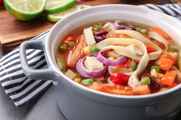 Chicken tortilla soup with vegetables on kitchen table