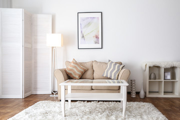 Interior of beautiful living room with folding screen and sofa