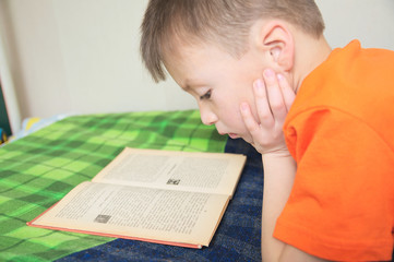 children education, kid reading book lying on bed, serious child read with book, education concept,...