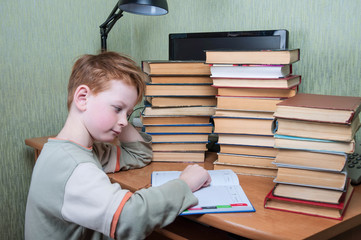 student doing homework, a large pile of books.