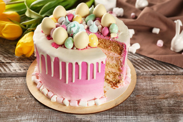 Sliced delicious Easter cake on wooden festive table