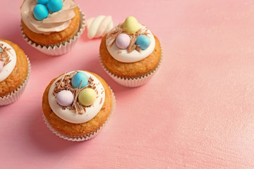 Tasty Easter cupcakes on pink background