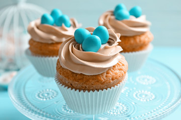 Decorated Easter cupcakes on cake stand against blur background