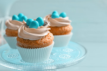 Decorated Easter cupcakes on cake stand against blur background
