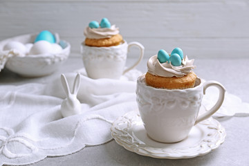 Delicious cupcake in porcelain cup on grey background