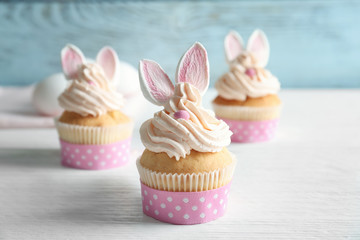 Decorated Easter cupcakes on white wooden table