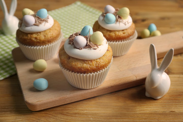 Delicious Easter cupcakes on wooden cutting board