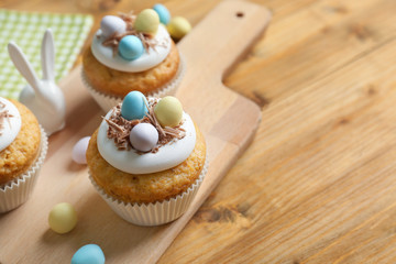 Delicious Easter cupcakes on wooden cutting board