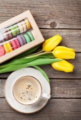 Colorful macaroons, coffee cup and yellow tulips