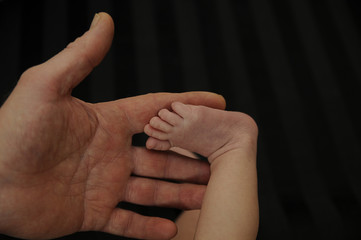 men's hand and foot of a newborn