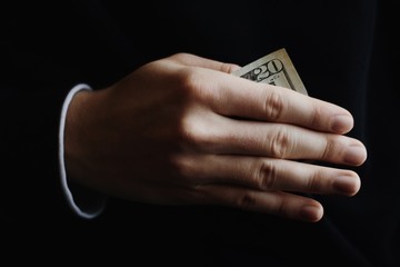 Hand holding money as a bribe - 139861683