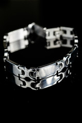 Silver bracelet on black glass