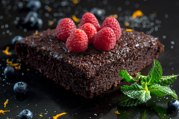 Chocolate cake with raspberries, blueberries, orange zest and pipermint
