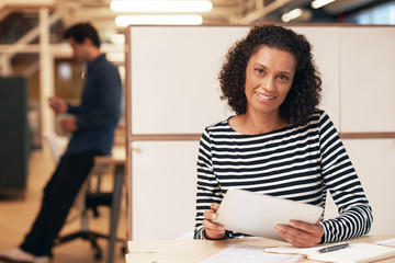 Smiling businesswoman working on a tablet in an office