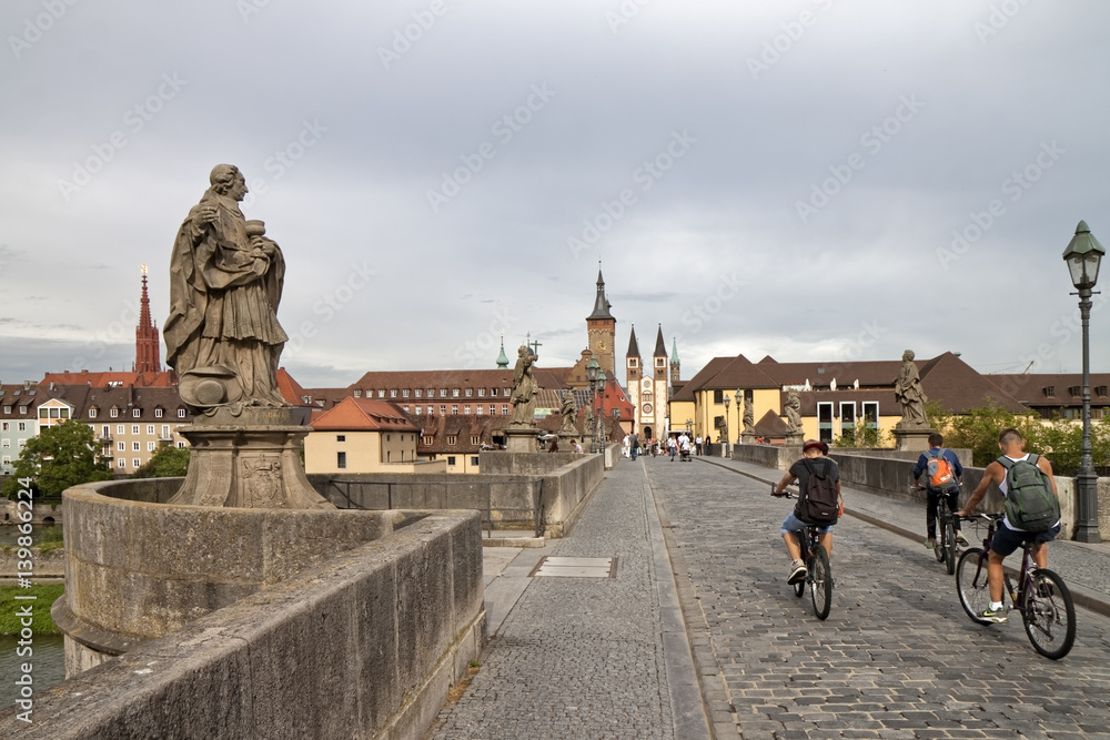 Wall mural würzburg, germany - cyclists on the way to the old town