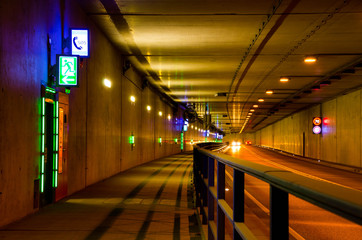Car driving through a tunnel with speed limit 70 kmph. Emergency exit in a tunnel
