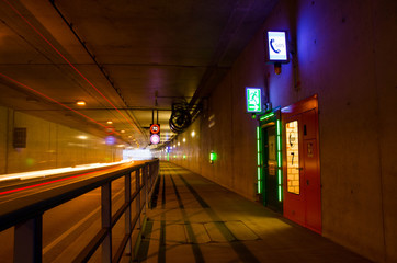 Auto fährt durch einen Tunnel mit Geschwindigkeitsbegrenzung 70 km/h. Notausgang in einem Tunnel