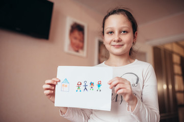 The girl shows her drawing with her family and her house