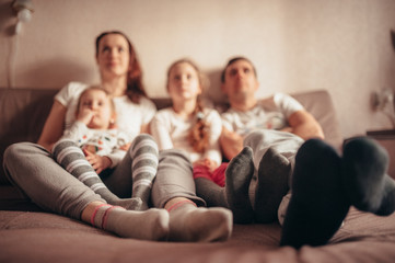 Feet of a family sitting on the couch. in focus