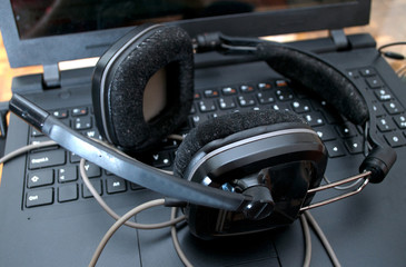 Black large dj headphones left on the laptop after mixing music