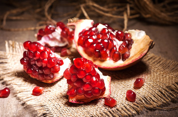 Fresh peeled pomegranates with ruby red beans on old wooden table