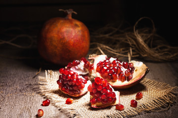 Fresh peeled pomegranates with ruby red beans on old wooden table