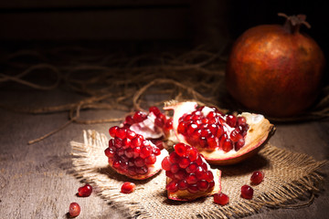 Fresh peeled pomegranates with ruby red beans on old wooden table