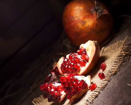 Fresh peeled pomegranates with ruby red beans on old wooden table