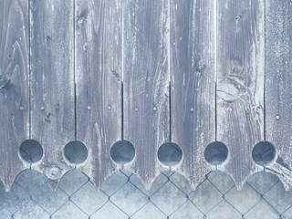 The faded blue wooden fence