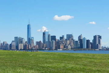 Fototapeta premium New York city skyline and green meadow, blue sky in a sunny day