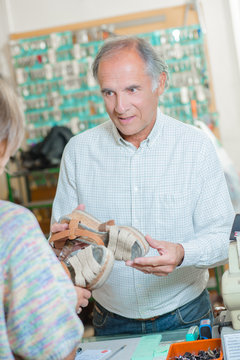 Cobbler explaining what needs to be done to a shoe