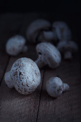 Mushrooms champignons on a wooden table, rustic style, moonlight, with a soft focus and blur
