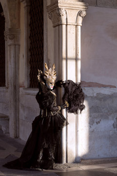 Aristocratic appearance: Venetian mask, noble costume, black velvet, golden headdress - Carnival in Venice