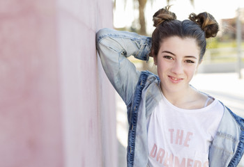 Portrait of teenage girl huddled on a purple wall.