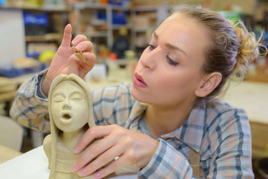 artist blowing a statue
