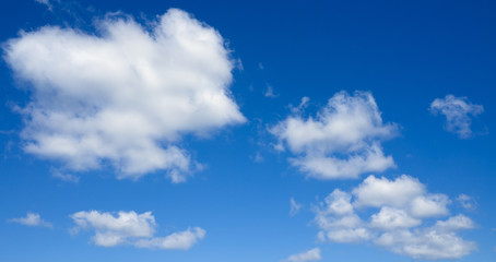 Naklejka na ściany i meble Panorama of white clouds flying against blue sky.