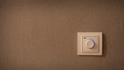 Switch button on the wall. Electrical round light switch on the wall.