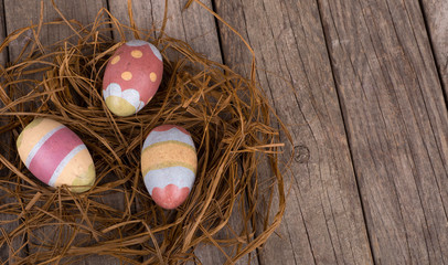 Easter Eggs in a Nest on a Weathered Wooden Surface