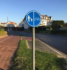 Bicycle and people walking sign on road