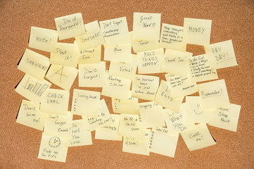 Many stickers for notes with text on the cork board