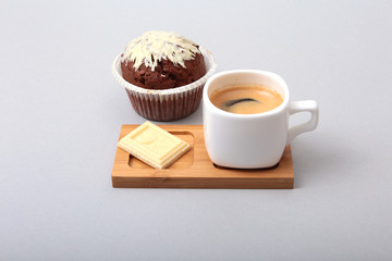 Classic espresso in white cup with cake and chocolate on white background.